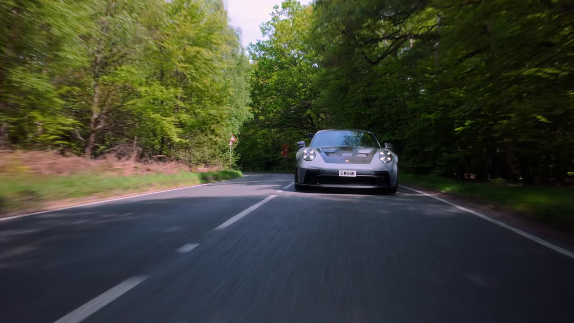 A Porsche 911 GT3 RS on a tree-lined road