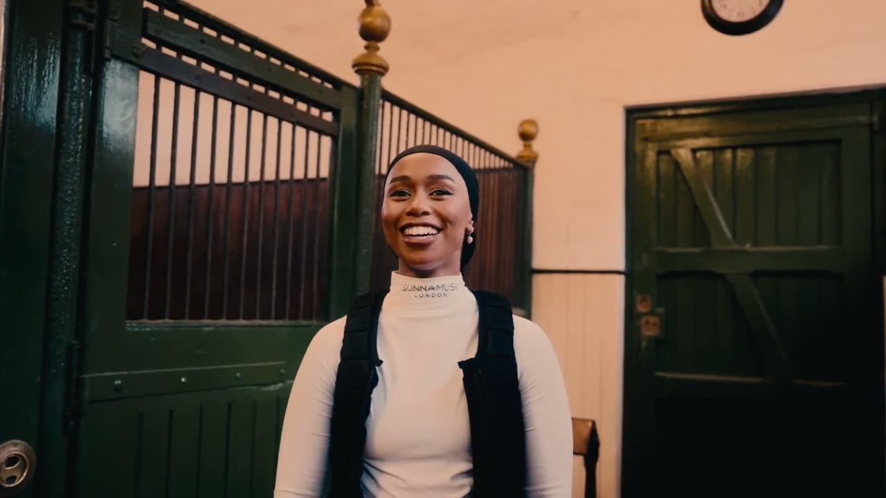 At the stable door, talking to camera